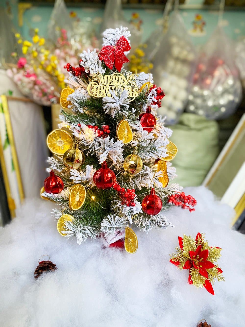 Cây thông mini phủ tuyết trang trí cam và bảng merry christmas